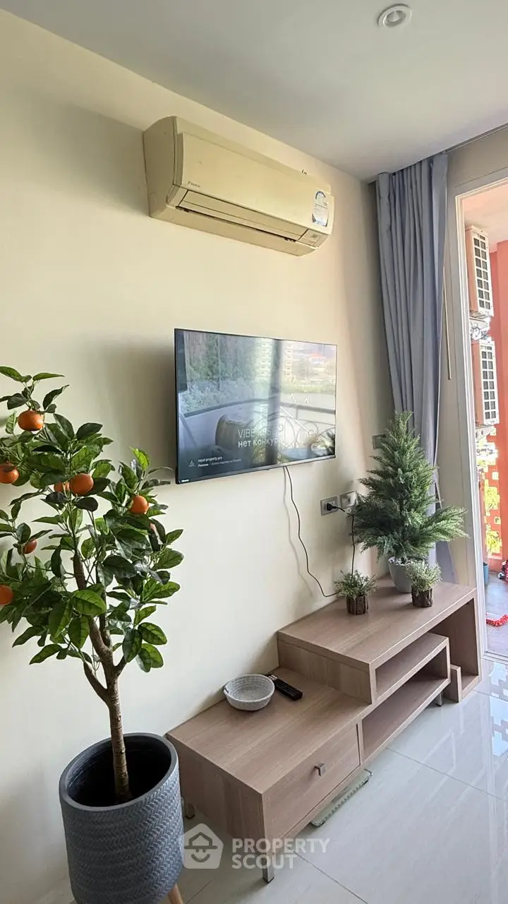Modern living room with air conditioning, TV, and stylish decor in a bright apartment.
