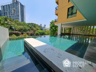 Luxurious apartment pool with stunning cityscape view and lush greenery