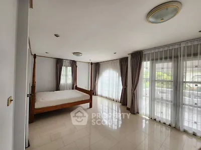 Spacious bedroom with large windows and elegant curtains