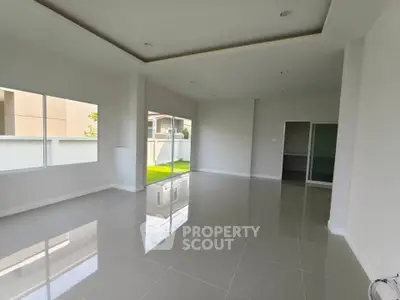 Spacious modern living room with large windows and glossy tile flooring