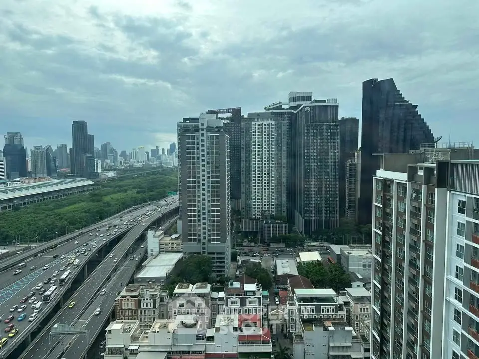 Stunning cityscape view from high-rise apartment showcasing urban skyline and lush greenery.