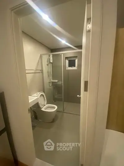 Modern bathroom with glass shower enclosure and sleek fixtures.