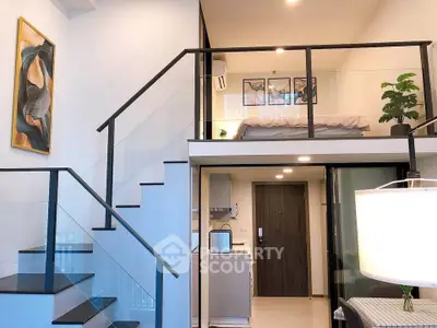 Modern loft apartment with stylish staircase and open layout, featuring a cozy mezzanine bedroom and sleek kitchen.