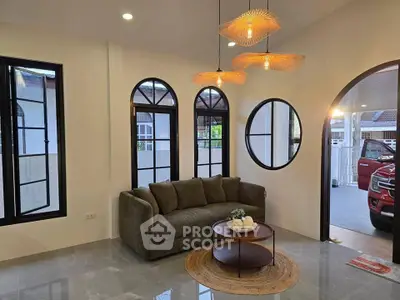 Stylish living room with modern sofa and unique lighting fixtures, featuring arched windows and a cozy ambiance.