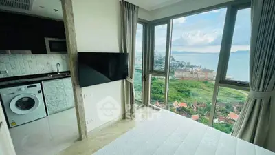 Stunning bedroom with panoramic ocean view and modern amenities in high-rise apartment.