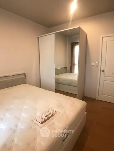 Spacious bedroom with mirrored wardrobe and cozy lighting