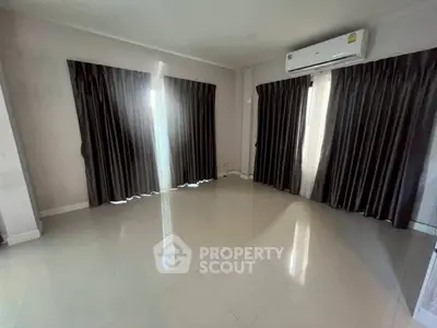 Spacious empty room with large windows and air conditioning, perfect for customization.