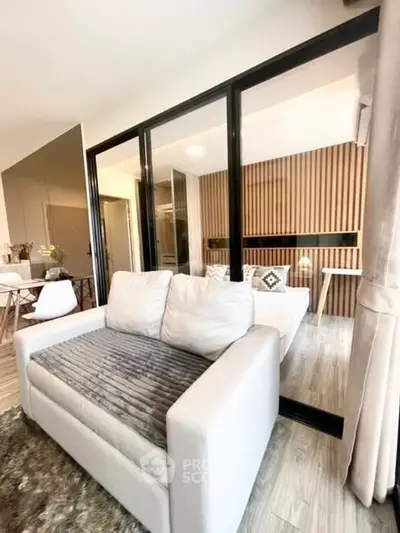 Modern living room with stylish glass partition and cozy seating area.