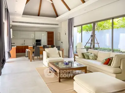 Spacious modern living room with open kitchen, high ceilings, and garden view, perfect for luxury living.