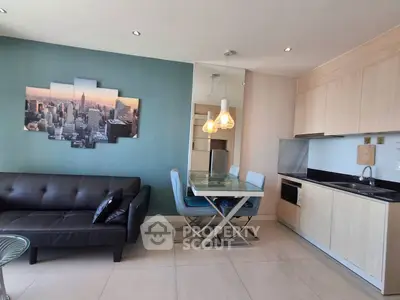 Modern living room with sleek kitchen and stylish decor in open layout apartment.