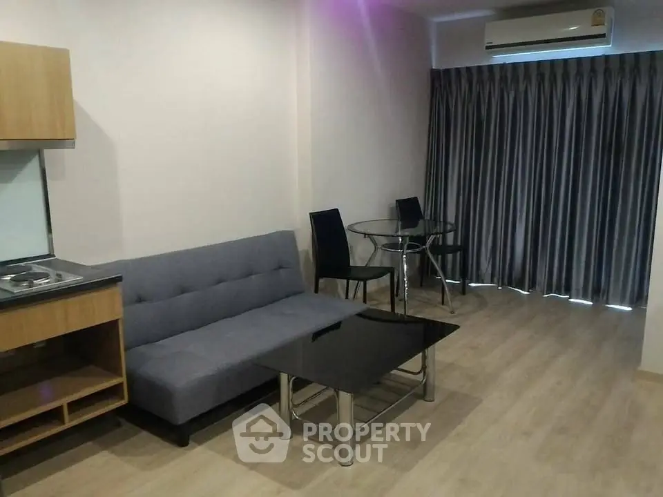 Modern living room with sleek furniture and wooden flooring, featuring a cozy sofa and dining area.
