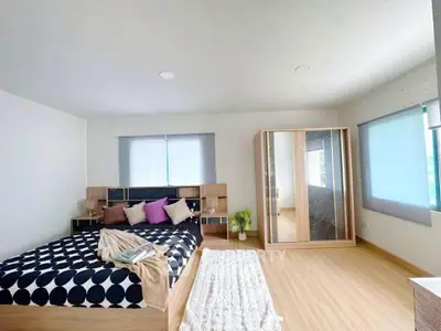 Spacious modern bedroom with stylish decor and ample natural light.