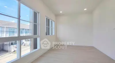 Bright empty room with large windows and wooden flooring in modern home