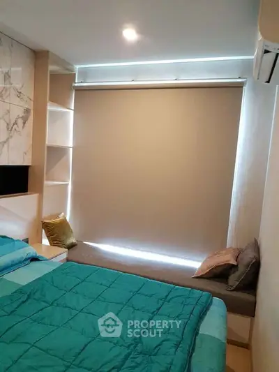 Modern bedroom with cozy bedding and stylish window seating, perfect for relaxation.