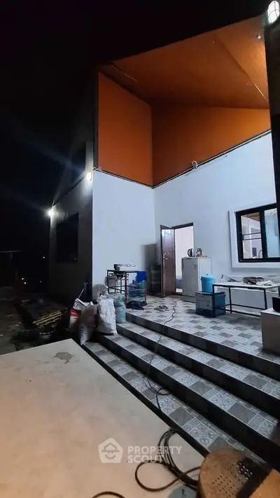 Modern exterior with spacious tiled steps and ambient lighting at night