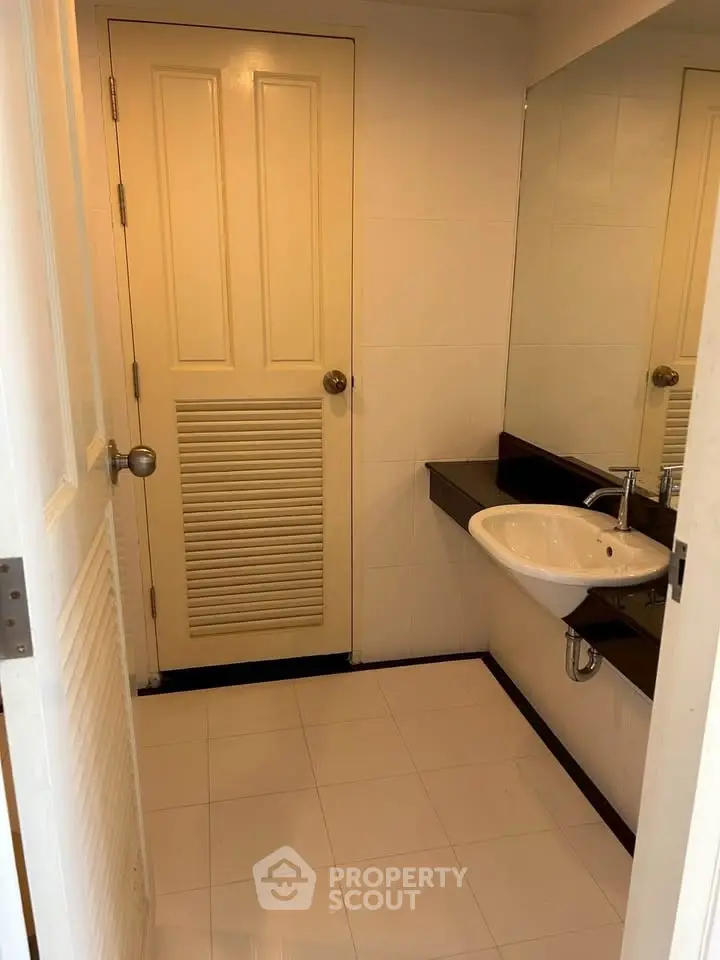 Modern bathroom with sleek sink and large mirror in a stylish real estate property.