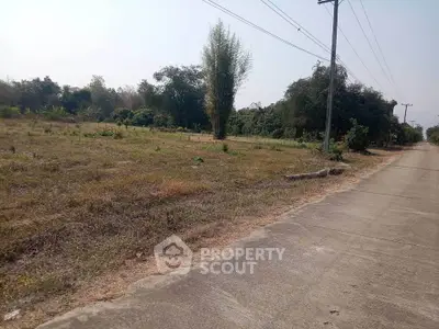 Spacious land plot with potential for development, featuring lush greenery and convenient road access.