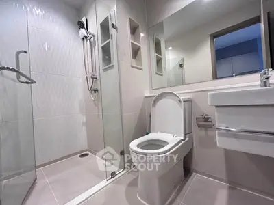Modern bathroom with glass shower and sleek fixtures in a contemporary apartment.