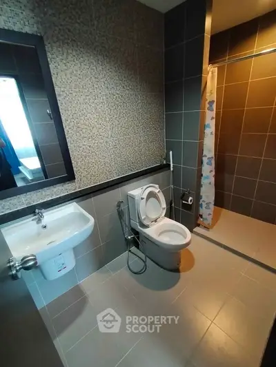 Modern bathroom with sleek design, featuring a shower area and stylish fixtures.