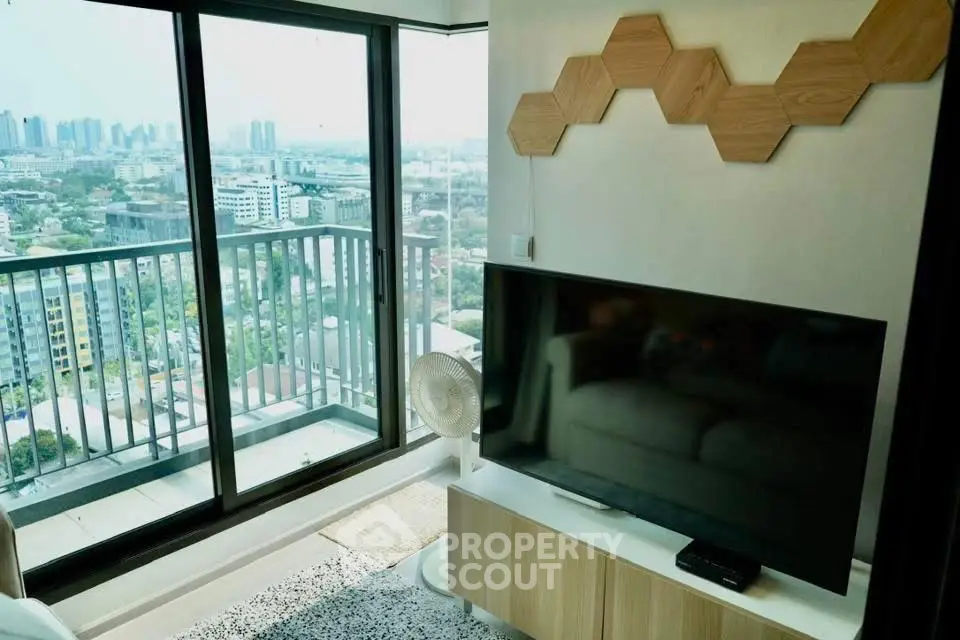 Modern living room with stunning city view from large balcony, featuring stylish decor and entertainment setup.