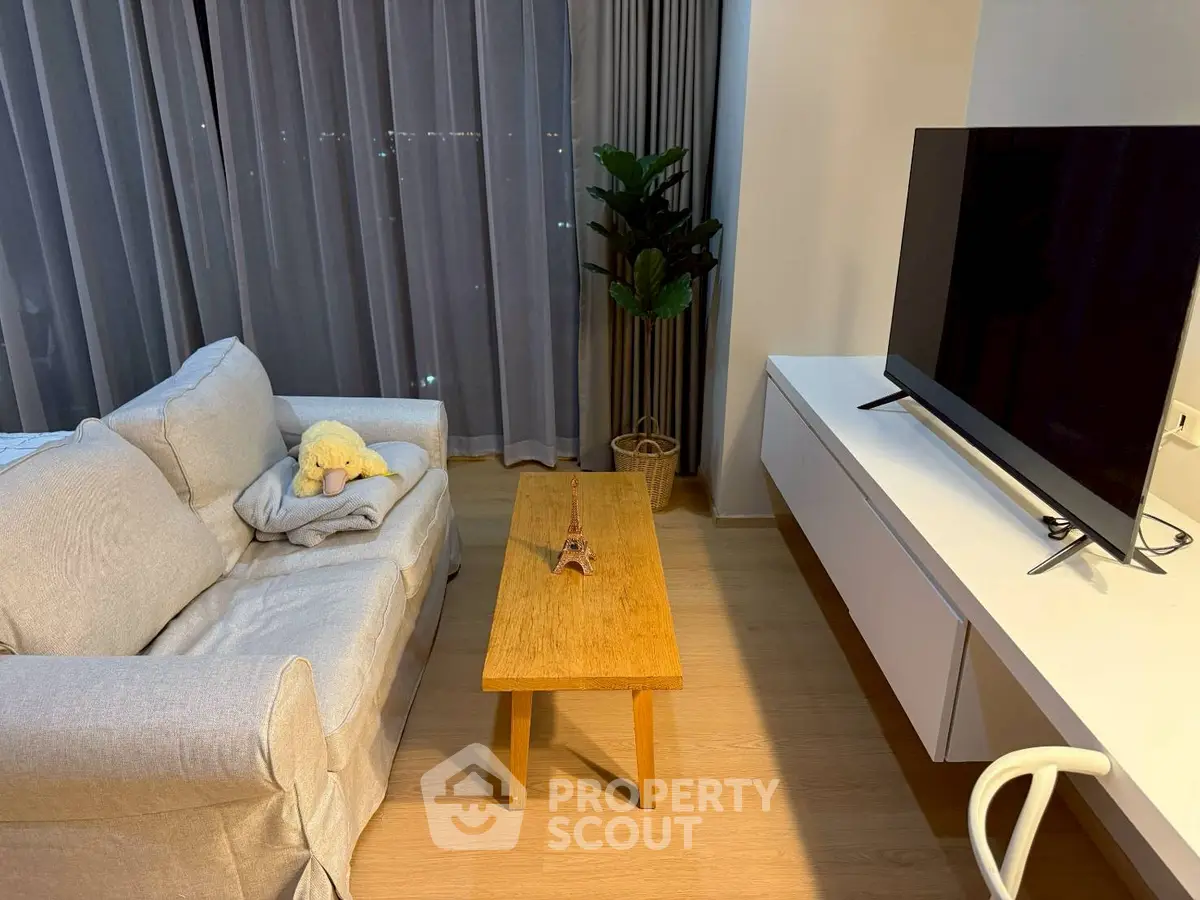 Modern living room with cozy sofa, wooden coffee table, and large TV, perfect for relaxation and entertainment.