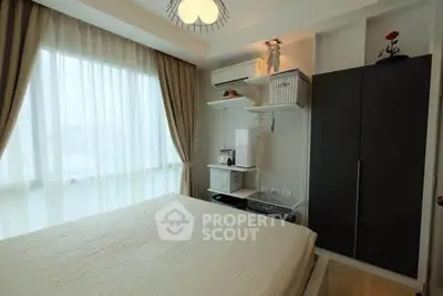 Cozy bedroom with large window and modern decor in a stylish apartment.