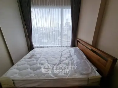 Spacious bedroom with large window offering stunning city views, featuring a comfortable bed and elegant decor.