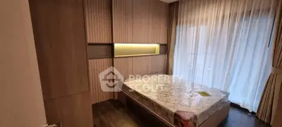 Modern bedroom with elegant wood paneling and large window with sheer curtains.