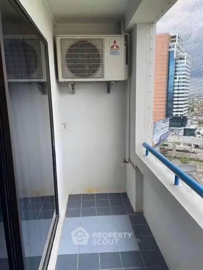 Compact balcony with city view and air conditioning unit, ideal for urban living.