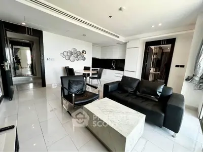 Modern living room with sleek black leather furniture and marble coffee table