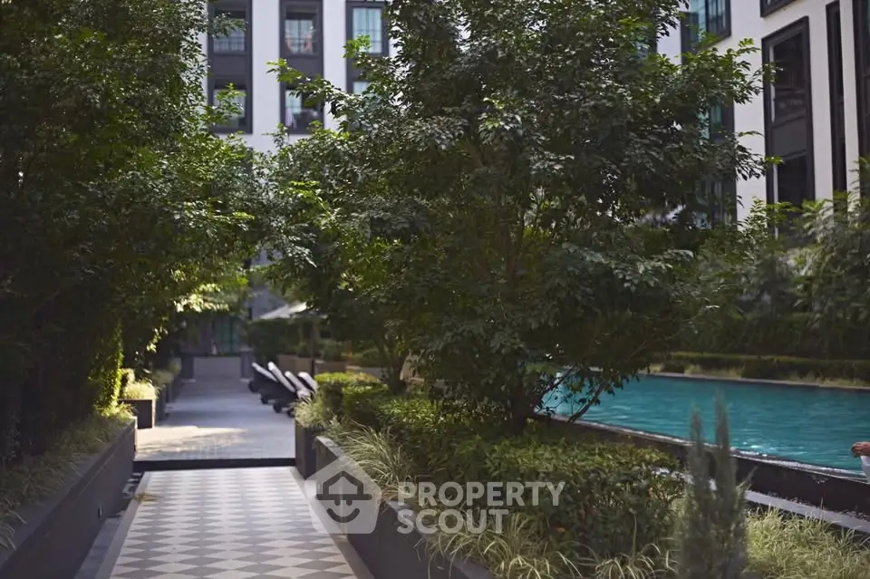 Luxurious residential building with lush garden and inviting pool area, perfect for relaxation and leisure.