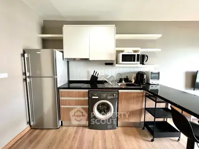 Modern kitchen with sleek appliances and washing machine in stylish apartment.