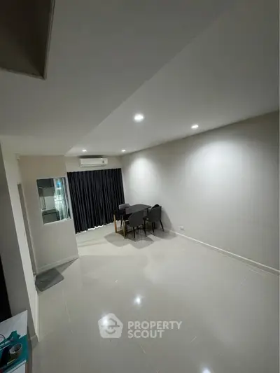 Spacious modern living room with sleek tile flooring and elegant dining setup.