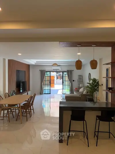 Spacious open-plan living and dining area with modern decor and natural light.