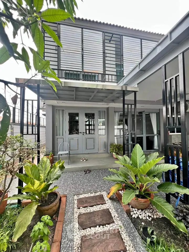 Charming modern house exterior with lush garden and stylish pathway