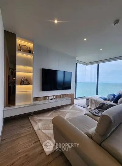 Luxurious living room with ocean view, modern decor, and large TV, perfect for relaxation.