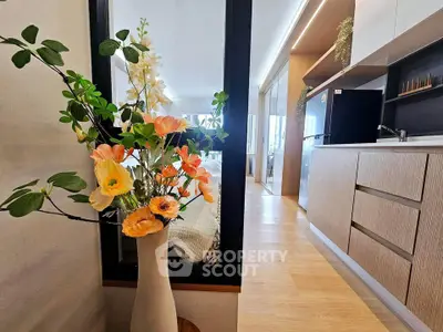 Modern kitchen with sleek cabinetry and vibrant floral arrangement, showcasing contemporary interior design.