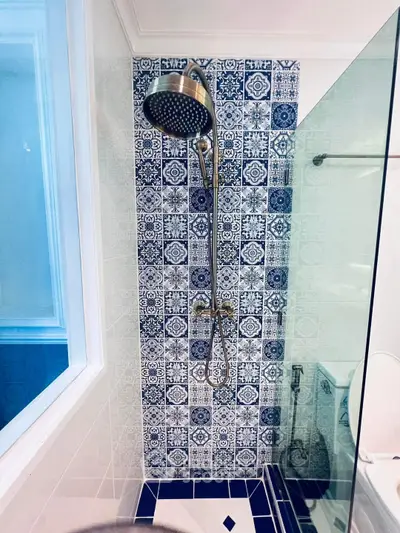 Stylish bathroom with patterned tiles and modern showerhead