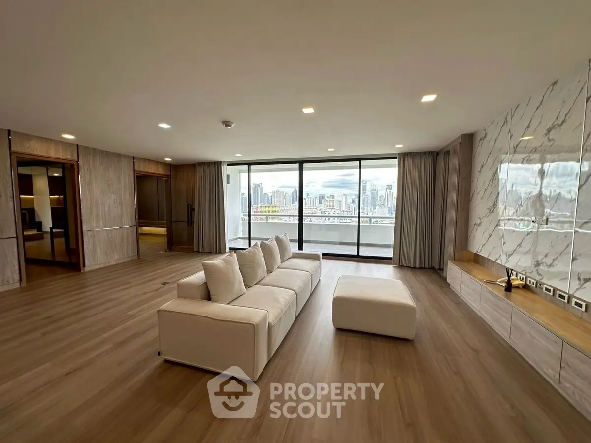 Spacious modern living room with stunning city view and elegant marble accents.