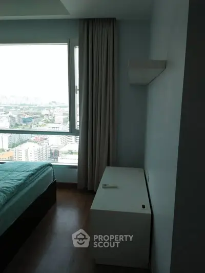 Modern bedroom with large window offering panoramic city view