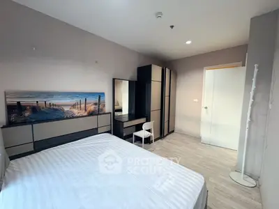 Modern bedroom with stylish furniture and beach-themed artwork, perfect for relaxation.