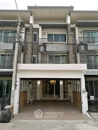Modern three-story townhouse with spacious garage and elegant facade.