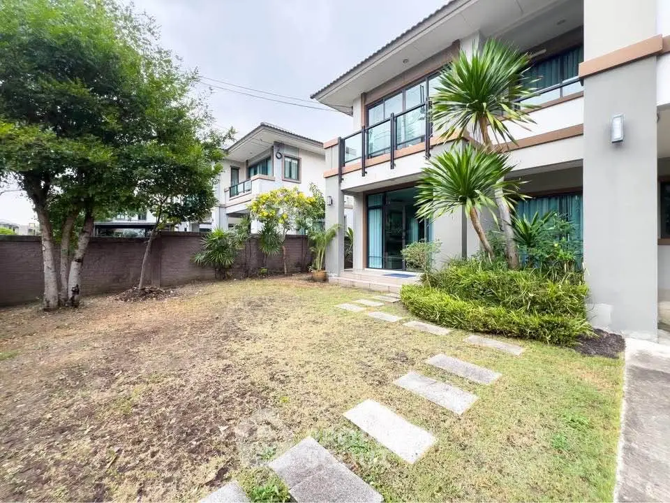 Charming two-story house with lush garden and modern facade in a serene neighborhood.