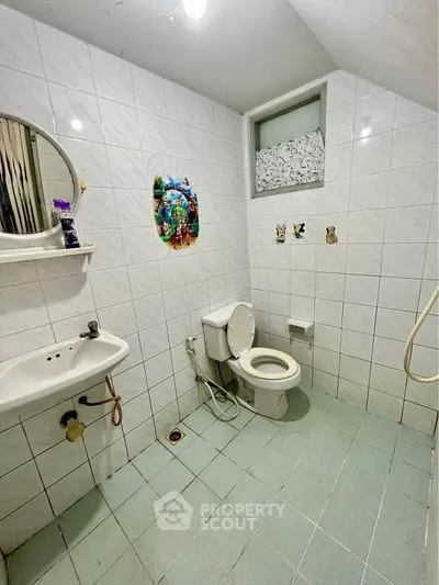 Spacious bathroom with white tiles and modern fixtures