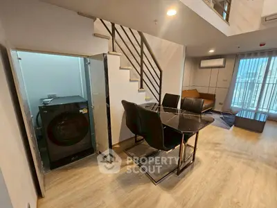 Modern duplex living room with sleek dining area and built-in washing machine.