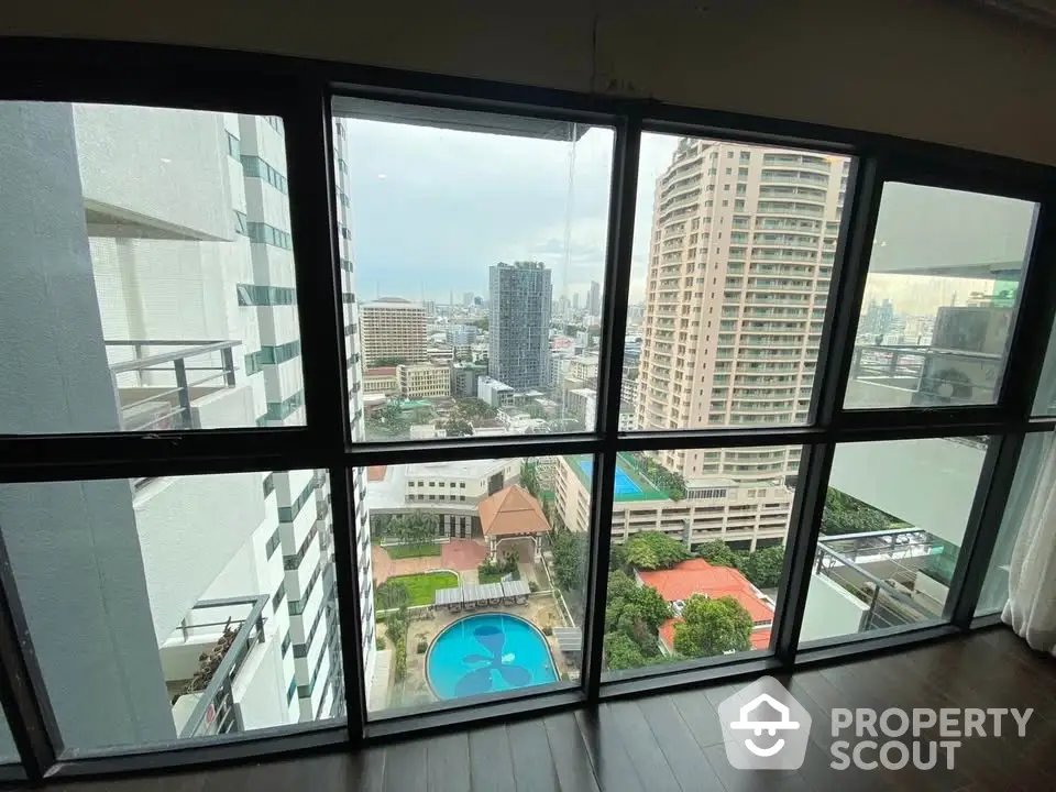 Stunning high-rise apartment view with cityscape and pool, offering urban living at its finest.