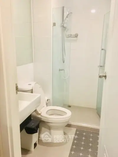 Modern bathroom with glass shower and sleek fixtures in a contemporary apartment.