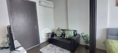 Cozy living area with black sofa, air conditioning, and modern decor in a stylish apartment.
