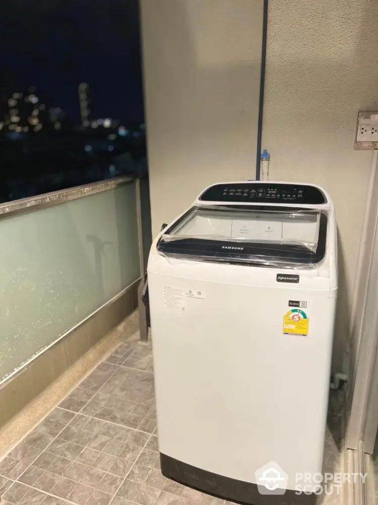 Modern balcony with washing machine and city view at night