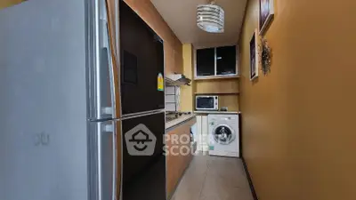 Compact kitchen with modern appliances including fridge and washing machine.